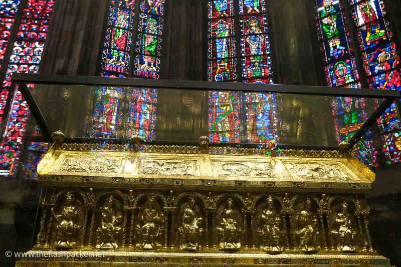 golden rectangular shrine and vibrant stained glass windows