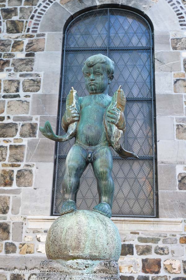 bronze sculpture of naked boy holding two fish