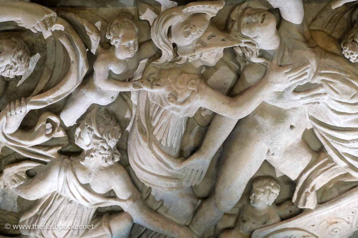 detailed carvings of figures on a marble sarcophagus