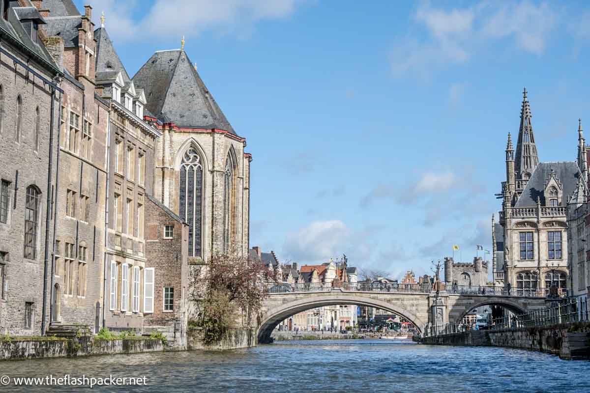 stone bridge crossing a canal in ghent surrounded by medieval buildings