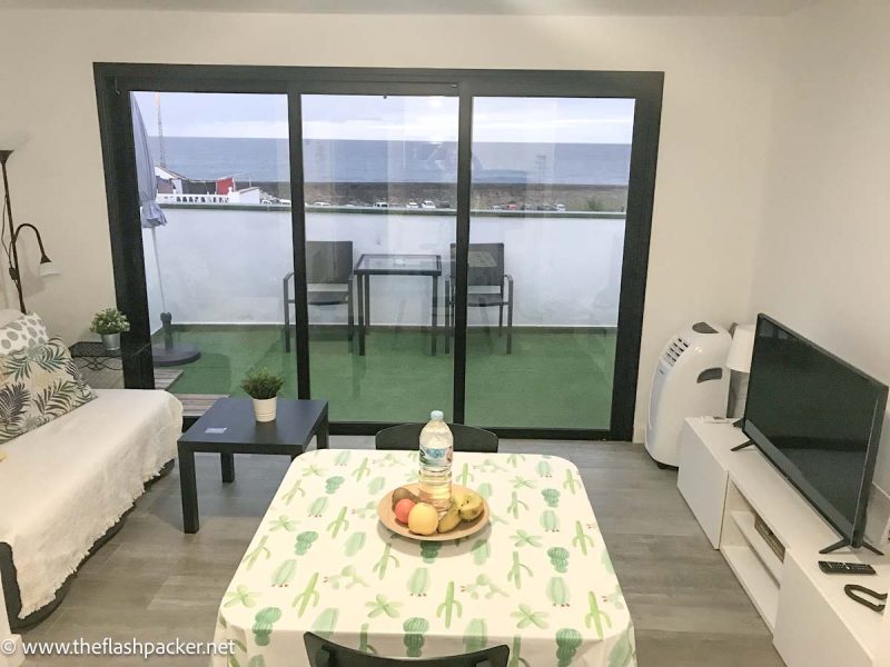 lounge with table with fruit bowl and terrace overlooking sea