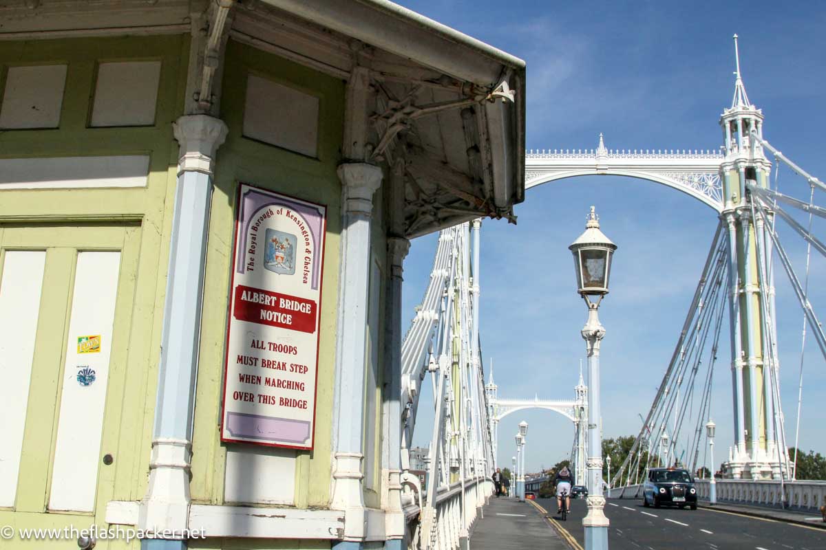 pales green and blue kiosk at end of pretty white bridge in london