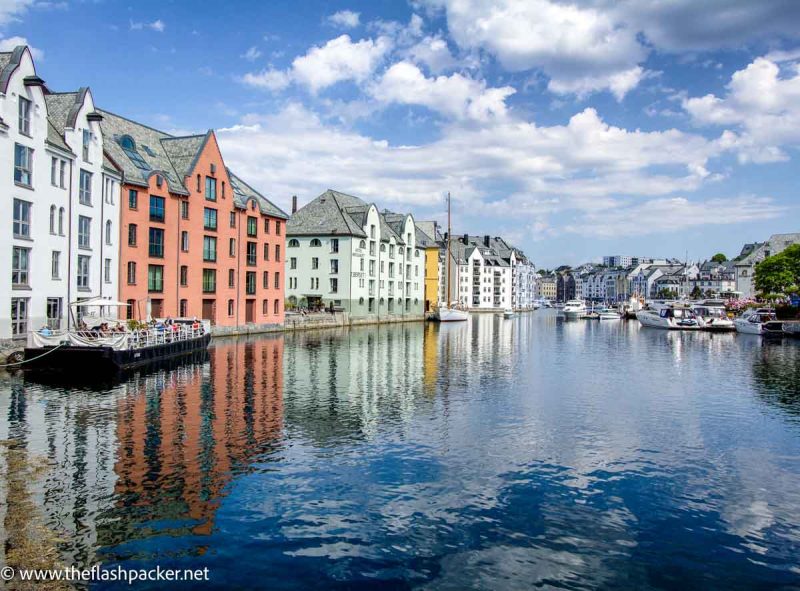 pastel colored buildings reflected in water in Alesund-Norway