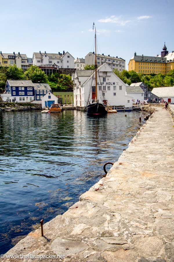 stone pier leading to wooden houses in alesund norway