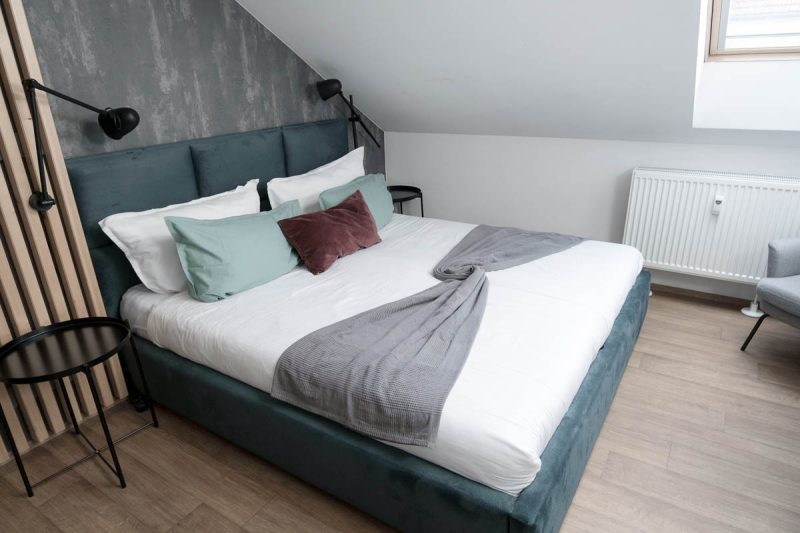 king size bed in a apartment with green and white bedding