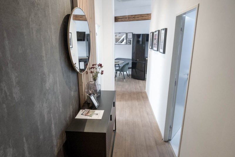 hallway in an apartment with a mirror and console table