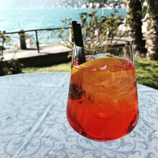 orange colored long cocktail in glass with straw