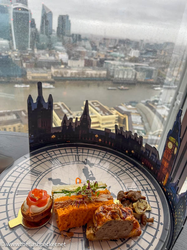 a savoury plate on a table next to a panoramic view of london