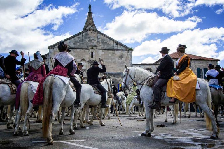 people dressed in medieval costumes on horses outside church in arles france