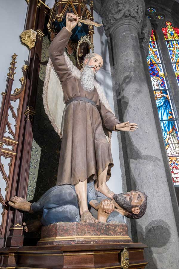 statue in church of a saint holding a knife whilst stepping on another man