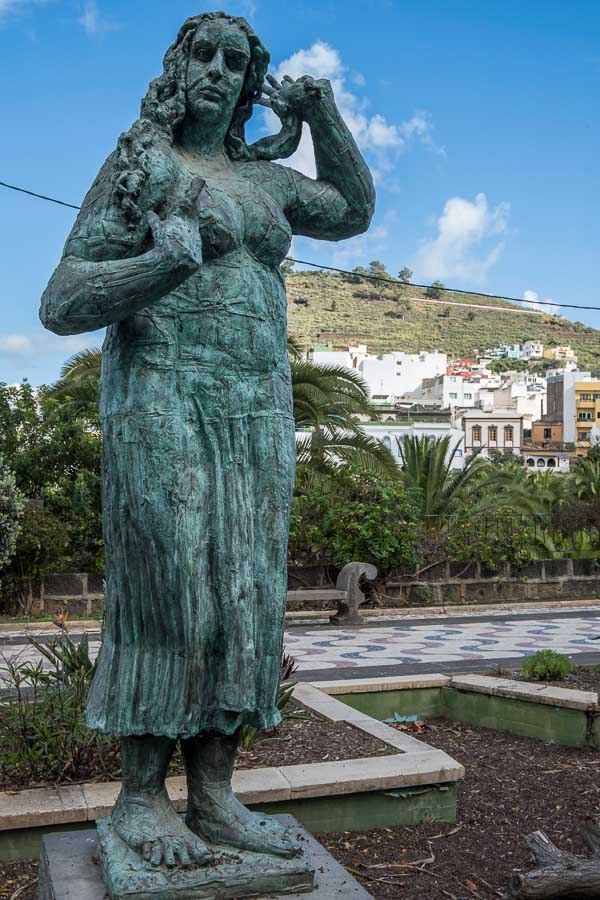 bronze statue of a woman in a park