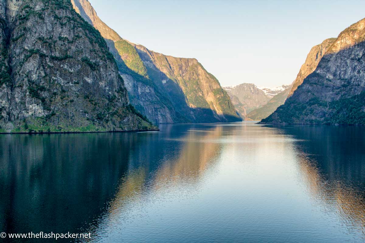 a fjord in norway with mountains reflected in water