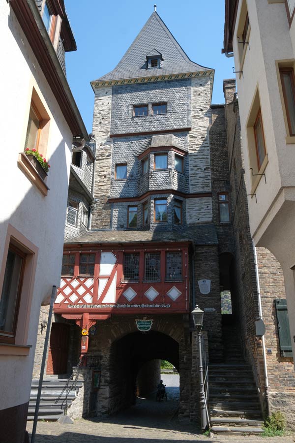 slate grey old toweroabove a red and white half-timbered building in bacharach in germany