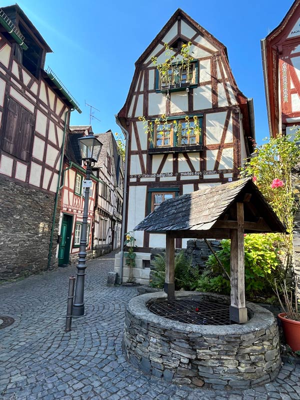 pretty little square in bacharach germany with small well and half timbered buildings