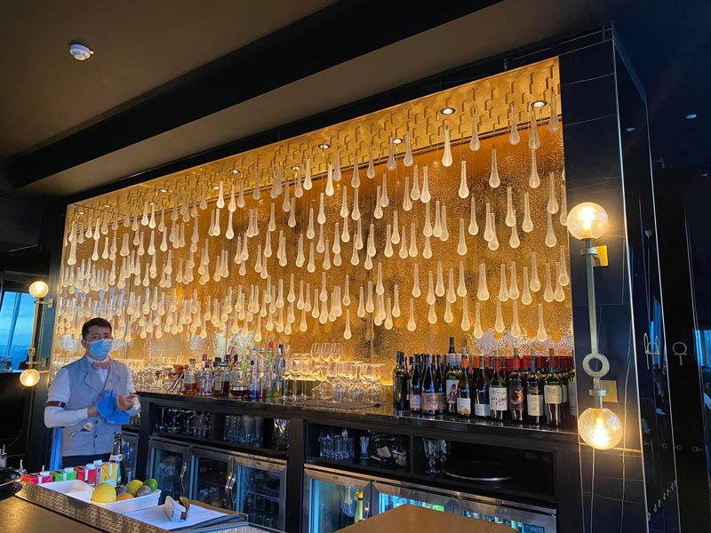 man cleaning glasses behind a high class bar