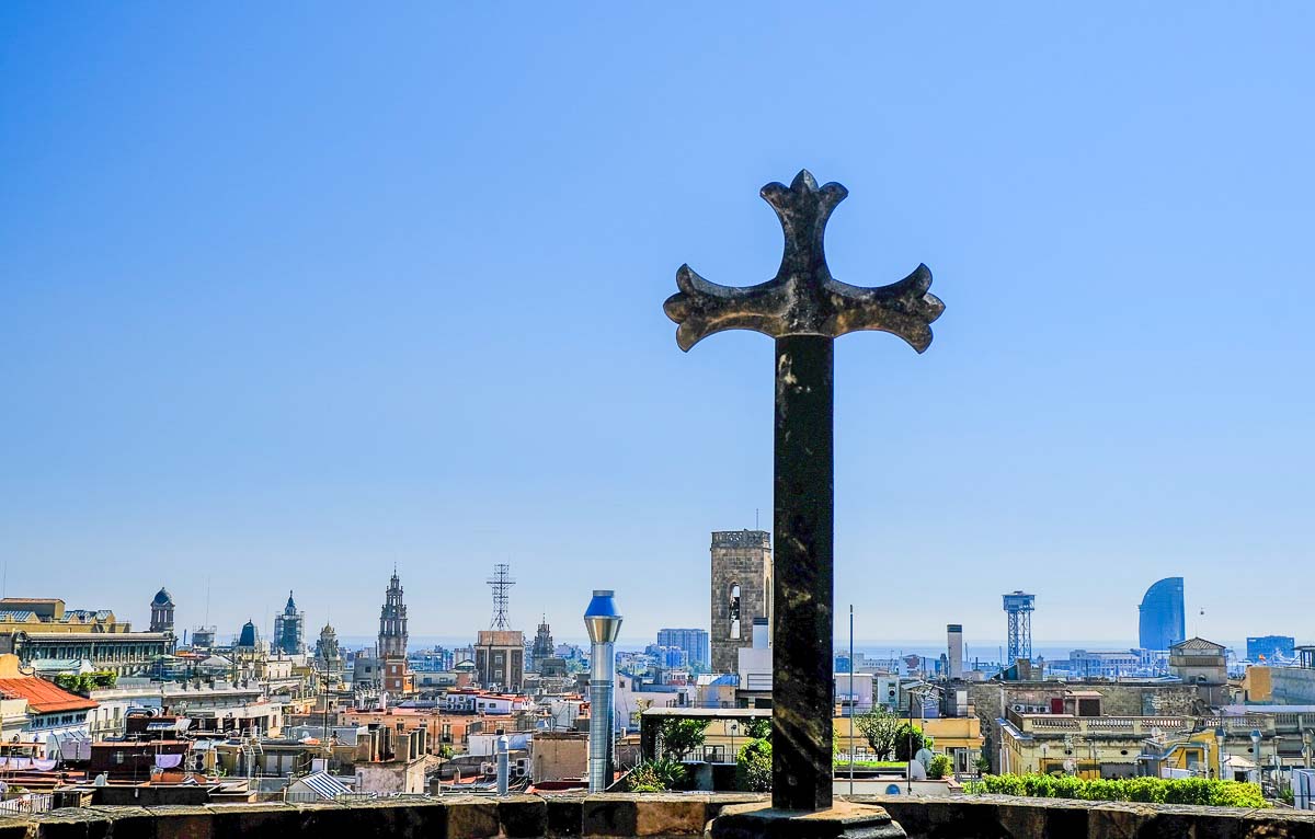 massive cross on rooftop of barcelona cathderal and skyline of city