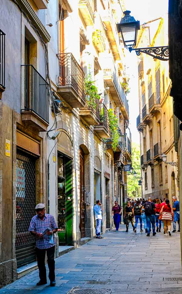 man walking along narrow street in barcelona spain