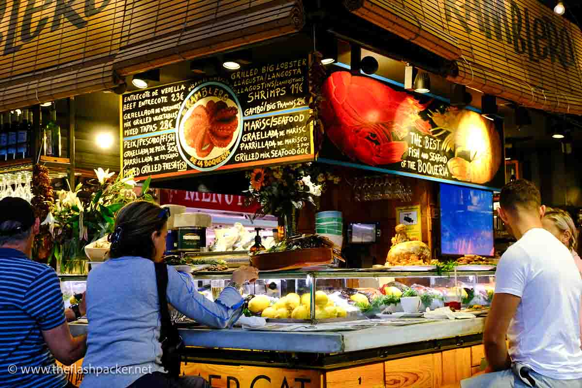 people eating at market stand