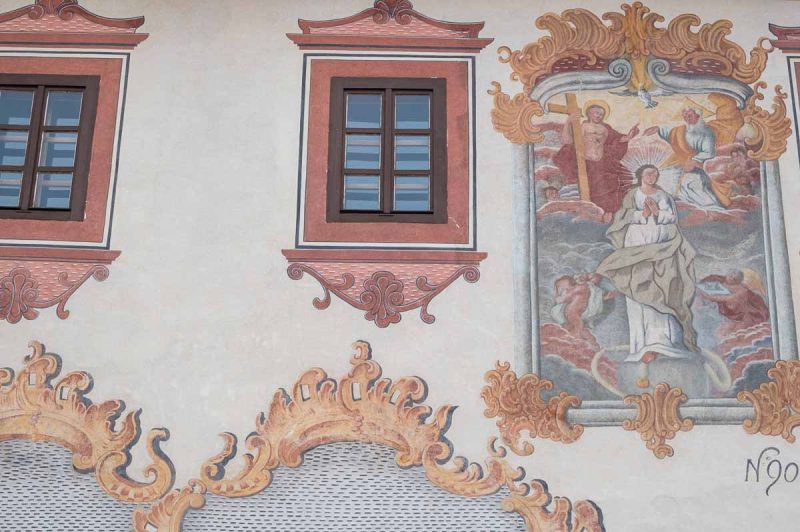 frescos on the exterior of a grey painted buildings in bardejov