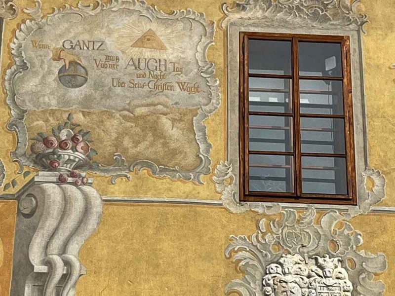 frescos on the exterior of a yellow painted buildings in bardejov