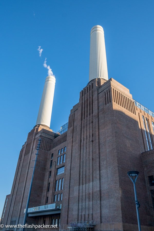 two white smoking chimneys of red brick power station