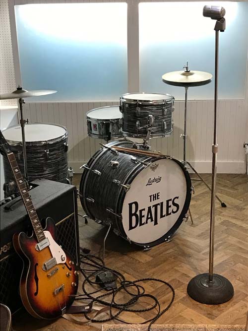 drum kit with the name of the beatles and a guitar