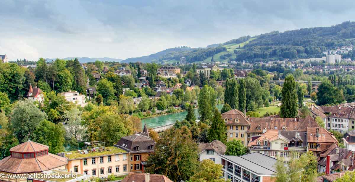 panoramic view of the city of bern with pea green river buildings and rolling hills