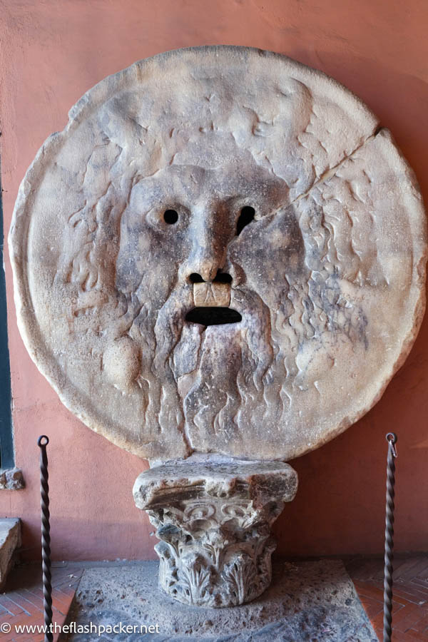 stone sculpture of the face of a mythical creature which is la bocca deklla verita in rome