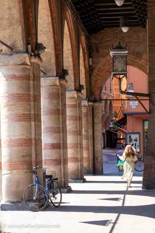 woman walking through an arcade in bologna