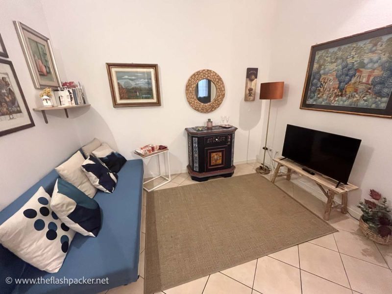 lounge of an apartment with blue sofa and a television