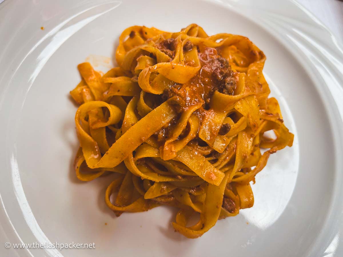 tagliatelle with ragu sauce on a white plate