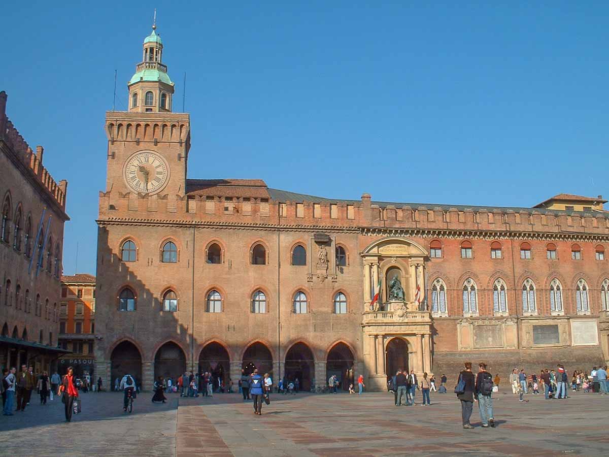 people-in-main-square-in-bologna-italy in front of medieval building with clock tower