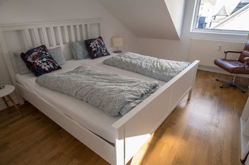 white wooden bed in an apartment