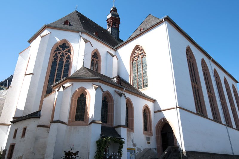 exterior of whitewashed boppard carmelite church with tall windows and single slim bell tower