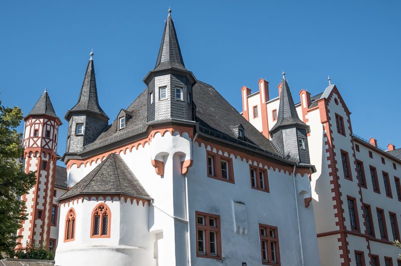 whitewashed castle-like building with salmon coloured window frames and grey turrets