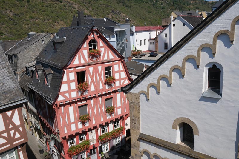 aerial view of side of whitewashed church and pink and white half-timbered building