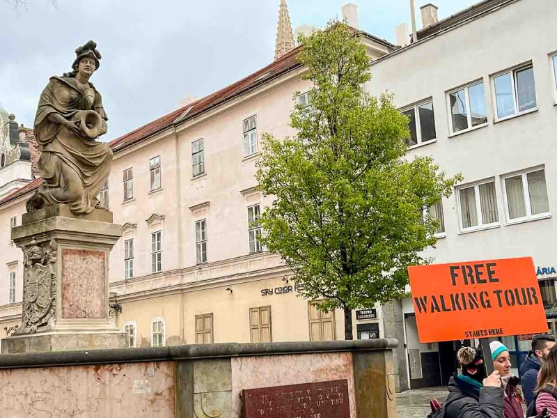 woman holding up a sign for free walking tour