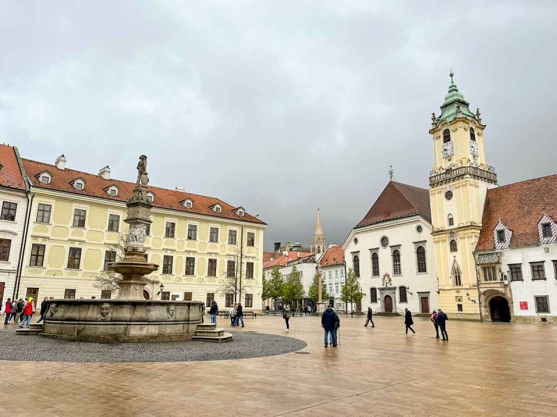 pretty main square in bratislava old town lined with old buildings and with a fountain in centre