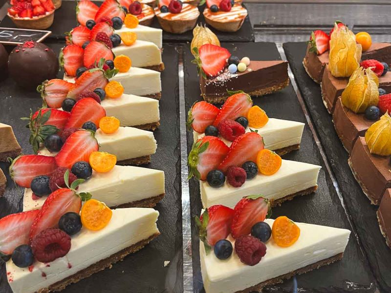 slices of cheesecake topped with fruit in a cabinet