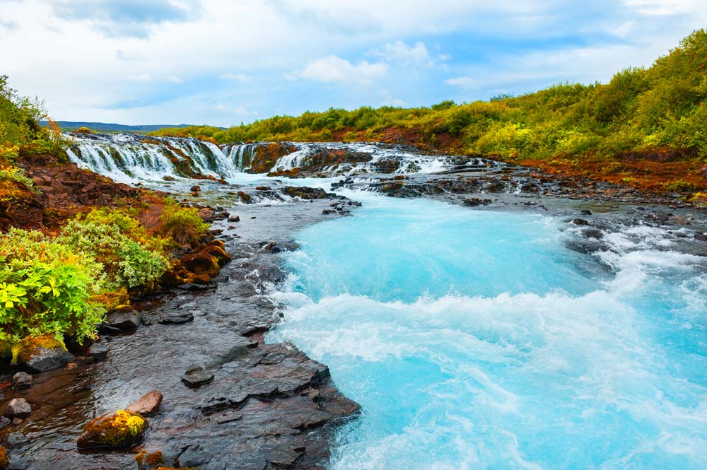 foaming sky blue water of bruarfoss waterfall one of iceland golden circle stops