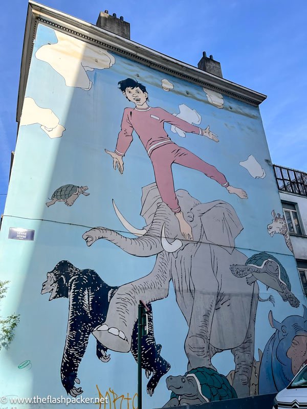 street art of boy elephant and other animals on a wall in brussels