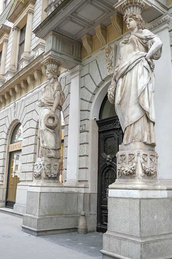 2 classical stone statues on either side of a doorway seen during solo travel in budapest