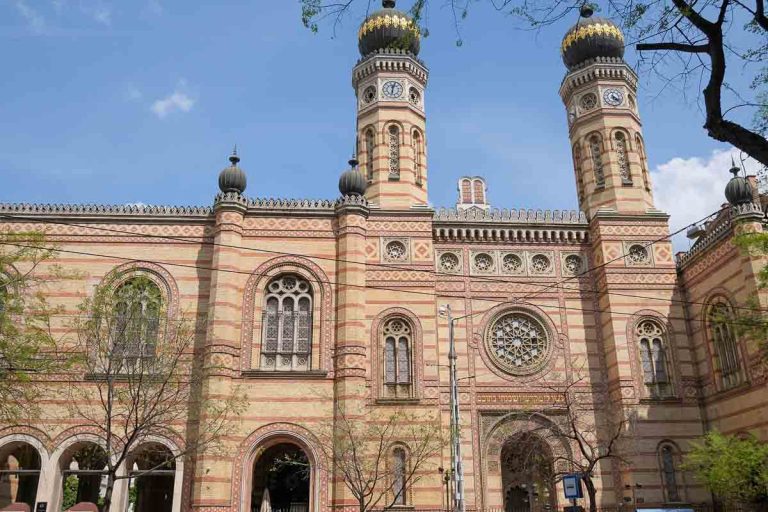 red brick exterior of budapest great synagogue with two clock towers