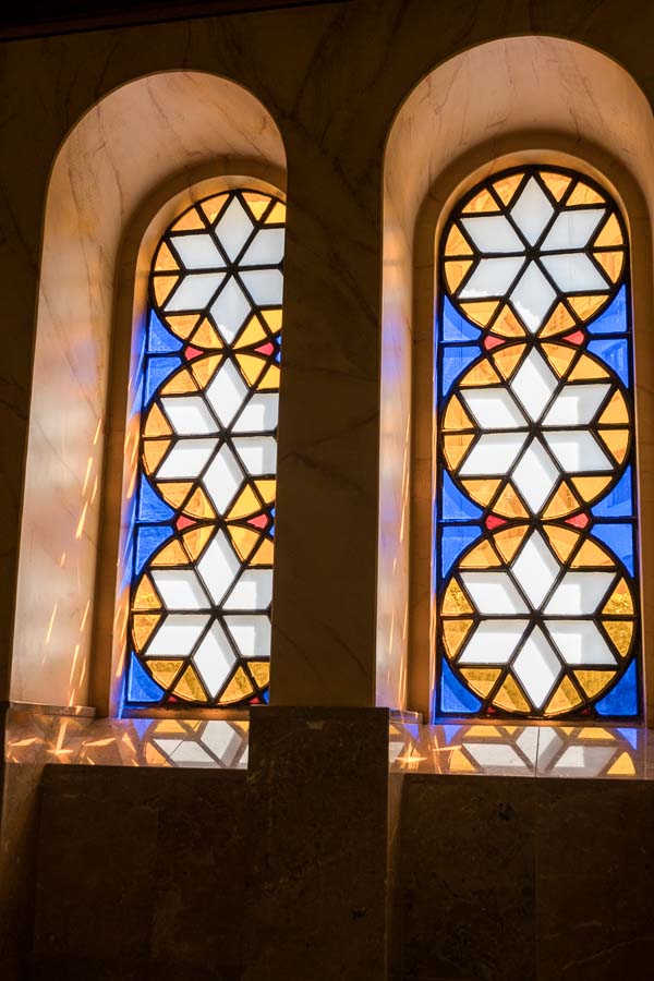 two arched stained glass windows with stars of david