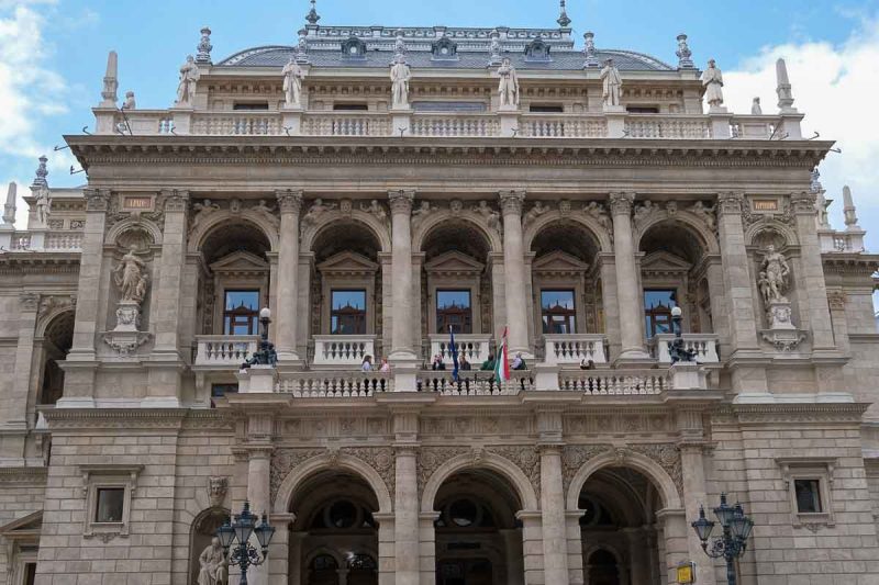 people standing on balcony of opera house in budapest