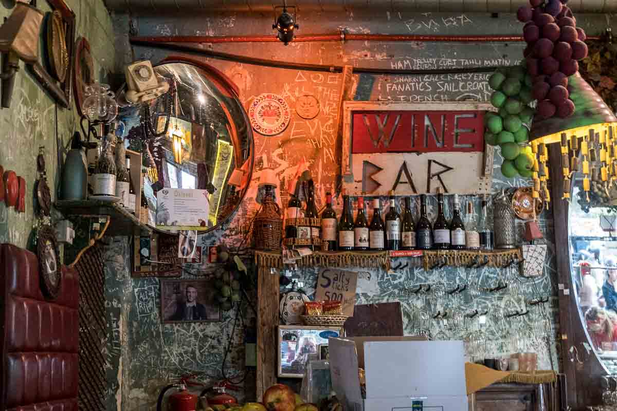 bottles of wine and beer on a shelf below a sign saying wine bar