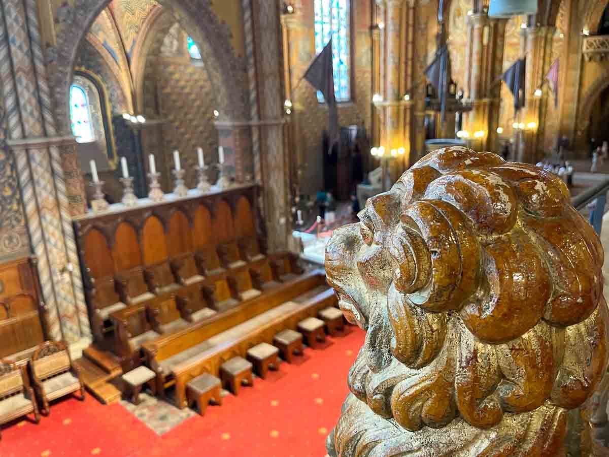 sculpture of a lion's head looking out over the floor of matthias church in budapest