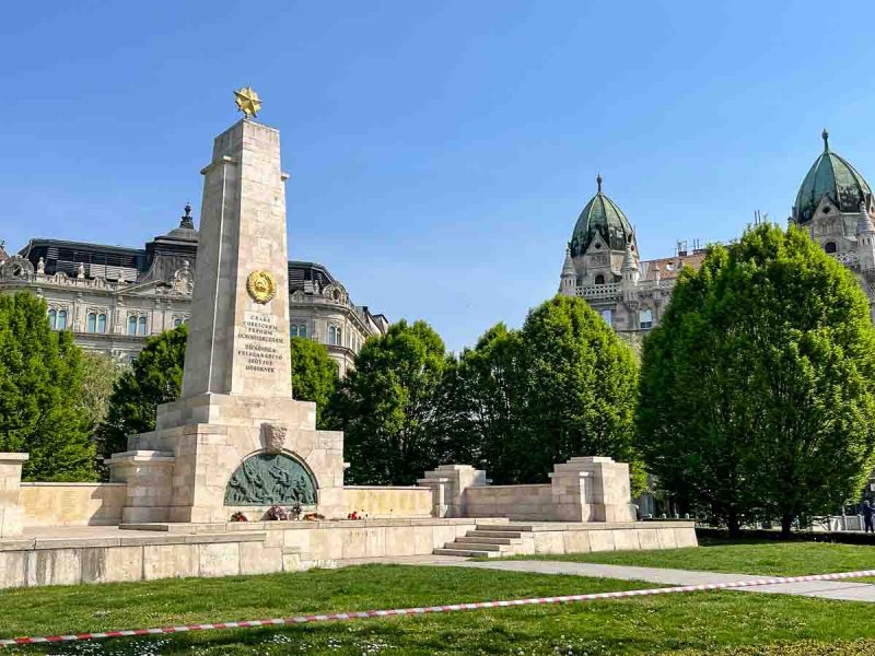 rectangular memorial in a park flanked by stately buildings