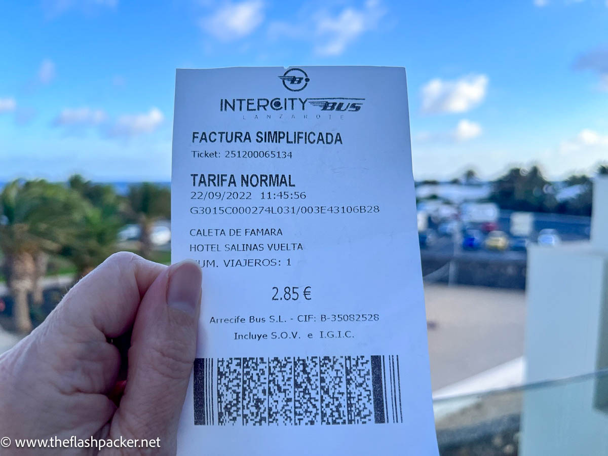 person holding up a lanzarote bus ticket