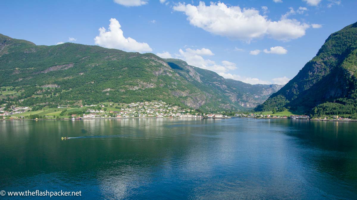 norway fjord with mountains reflected in water and blue sky